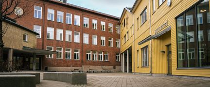 Entré till Gamlestadsskolan med några stenbänkar i bakgrunden.