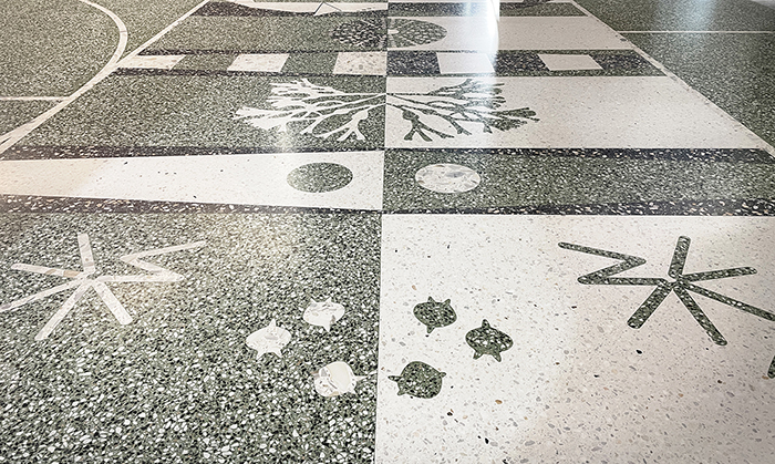 Ett golv med ett kontrasterande abstrakt m&ouml;nster i konststen i gr&aring;tt och vitt.