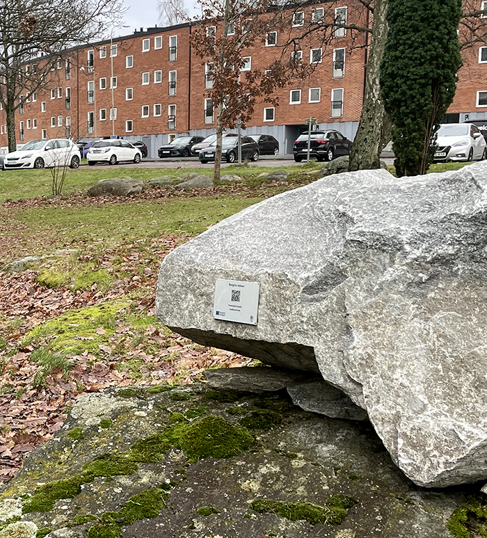 En skylt med en QR-kod sitter p&aring; en sten