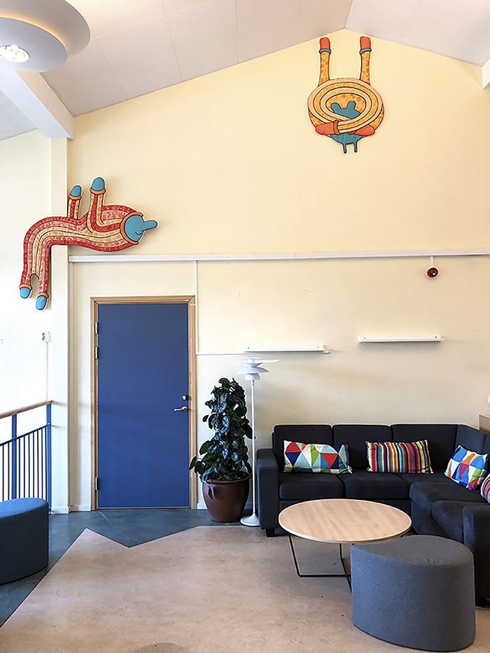 Tv&aring; lustiga figurer i textil ser ut att h&auml;nga i armarna fr&aring;n taket.