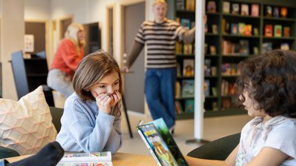  Ett foto av elever som pratar och spelar schack i ett skolbibliotek