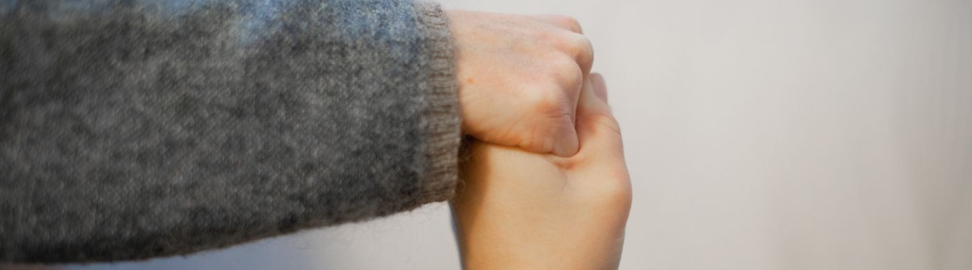 Två personer som håller varandras hand