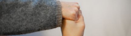 Två personer som håller varandras hand