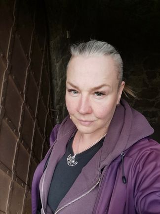 Porträtt av en person med svart tröja och lila hoodie