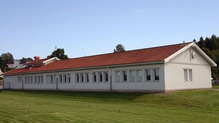 Björsaredsskolans huvudbyggnad med en skog i bakgrunden.