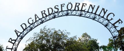 Närbild på Trädgårdsföreningens entréskylt i gjutjärn.