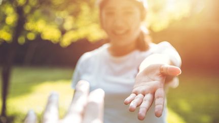 En person sträcker ut sin hand mot en annan.