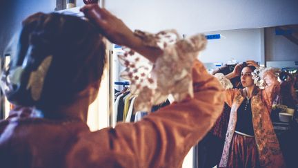 En elev i en dräkt med fantastiskt kråsärm i en omklädningsloge. 