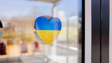 Flyktingboende med ett hjärta i Ukrainas färger som hänger i fönstret