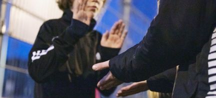 Två personer är på en idrottsplats och gör high ten på varandras händer.