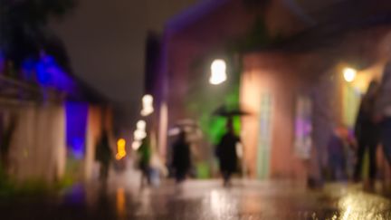 En suddig kvällsbild, i bakgrunden ser man siluetter av människor