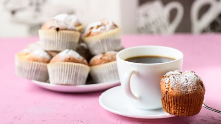 En kaffekopp och ett fat med muffins.