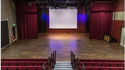 Scen med bioduk och röda soffor.