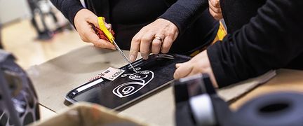 En person klipper bort en prislapp på en bricka.