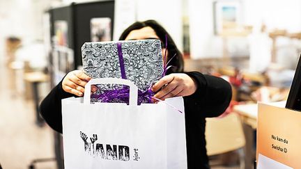 En person lägger ned en present i en påse.