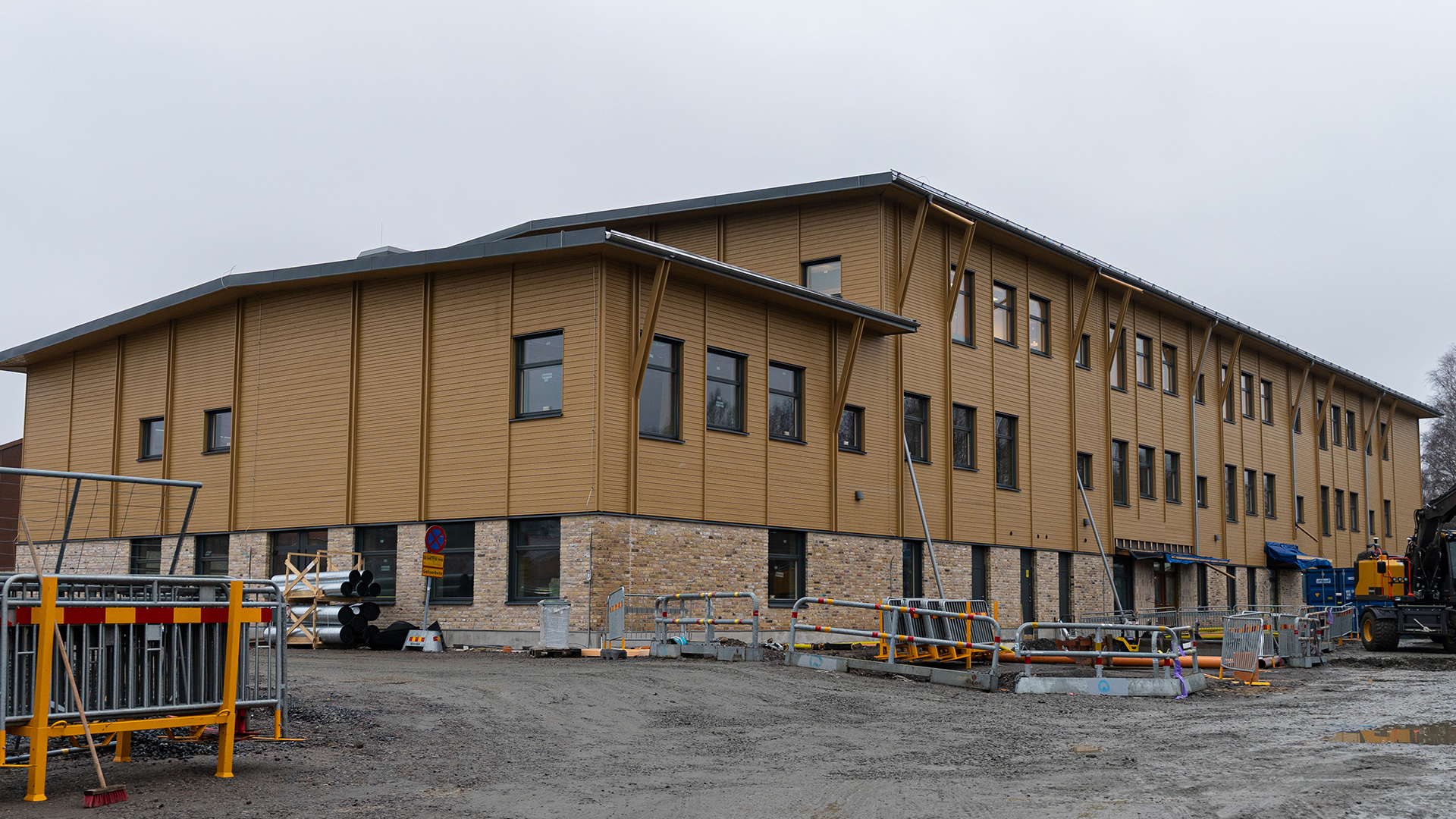 En gul byggnad i tre v&aring;ningar. Den nedersta v&aring;ningen i tegel, de tv&aring; &ouml;vre i tr&auml;panel.