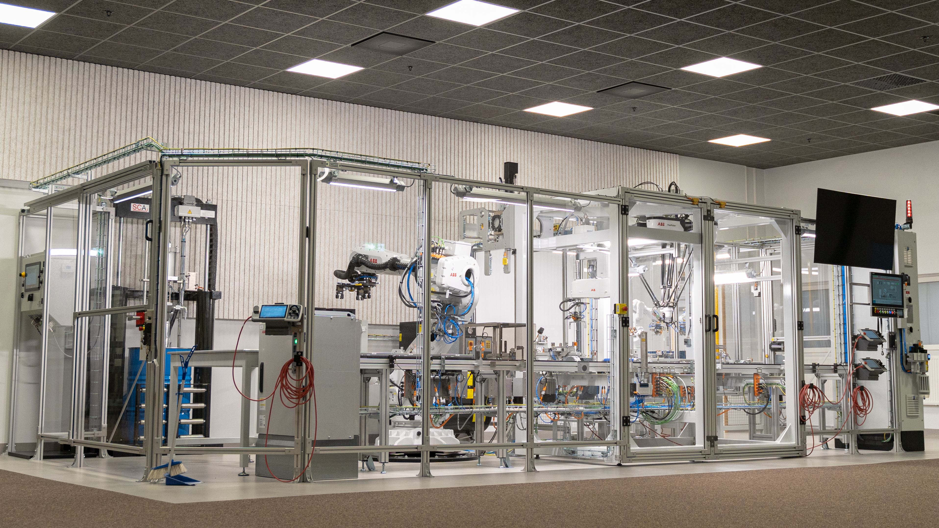 En glasbur med robotar som ska simulera tillverkningen av celler för batterier
