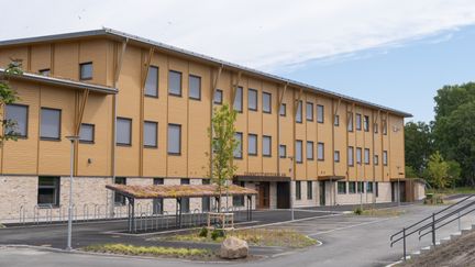 Ett stort hus med ljusgul träfasad och en skylt över ingången där det står Gunnestorpsskolan