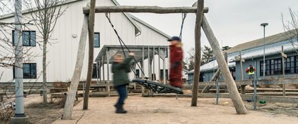 En lekplats med några barn som gungar utanför Styrsöskolan.