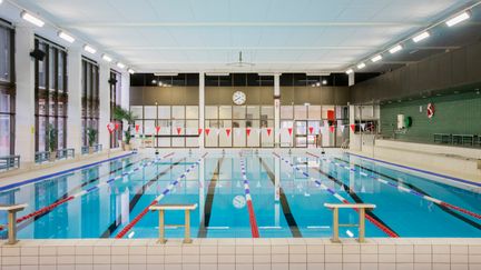 En simbassäng inomhus. Vattnet är lugnt.