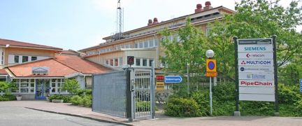 Ett stort gult hus innanför ett staket.