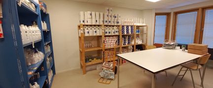 En arbetslokal med ett bord och hyllor längs väggarna.