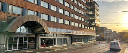 Tegelbyggnad i flera våningar och ett valv över entrén.