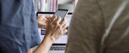 Närbild på händer som skrollar på en telefon