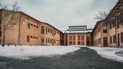 En överblick av Klarebergsskolan med skolbyggnaderna och några bänkar i bakgrunden.