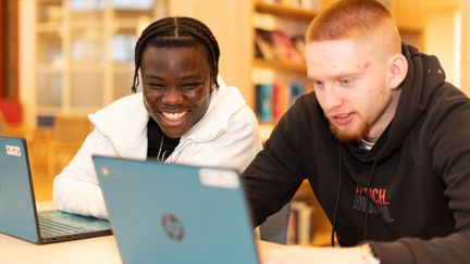 Två killar vid sina laptops.