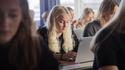 Elever vid datorer i klassrum.