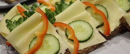 Rågsmörgåsar med ost och grönsaker serveras på brickor.