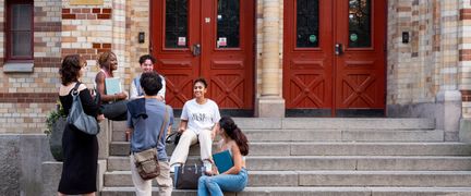 Six students in front of the school entrance