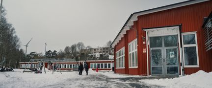 Långmosseskolans skolgård med några personer i bakgrunden.