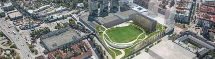 Flygbild över arenakomplex med fotbollsplan på taket och tillhörande höghus