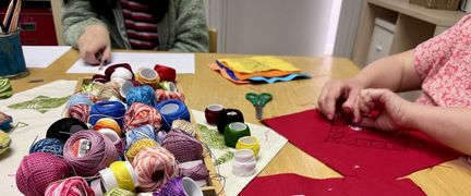 Aktivitetslokal med två personer som gör textilhantverk.