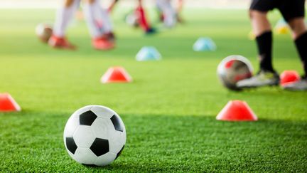 En fotbollsplan med koner och fotbollar.