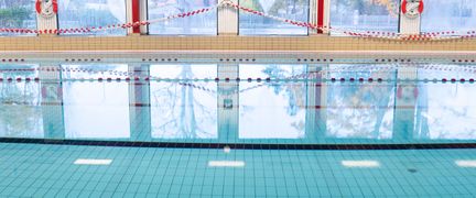 Bassängen i Askims simhall utan någon i vattnet. Vattnet är stilla.