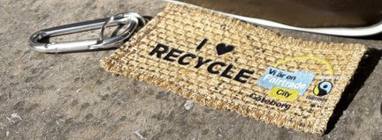 Närbild på bag tag av jute med texten I Love Recycle.