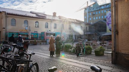 Magasinsgatan i motsol. Två personer går över den öppna torgytan. I förgrunden står cyklar parkerade.  