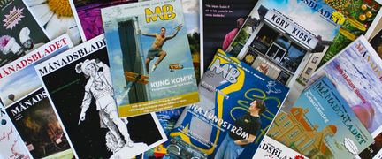 Flera nummer av tidningen Månadsbladet ligger på ett bord.