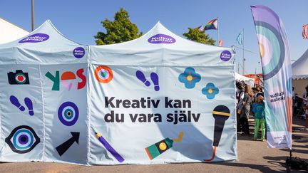 Kulturskolans stora utställningstält med färgrika illustrationer och texten Kreativ kan du vara själv.