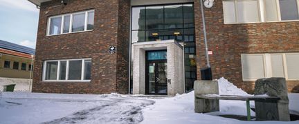 En entré till Bergsgårdsskolan med en bänk i bakgrunden.