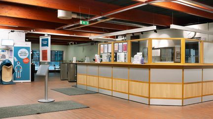 Kärra simhalls reception. Väggarna är gröna, och golvet är täckt med kakel. I taket syns mörka träbalkar.