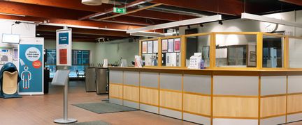 Kärra simhalls reception. Väggarna är gröna, och golvet är täckt med kakel. I taket syns mörka träbalkar.