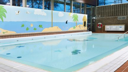 Kärra simhalls undervisningsbassäng. På väggen finns tecknade palmer, hav och fåglar.