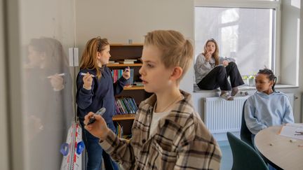  Ett foto av ett mellanstadiebarn i ett grupprum.