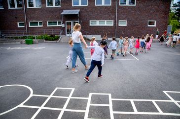 Barn som går på ett led över skolgården