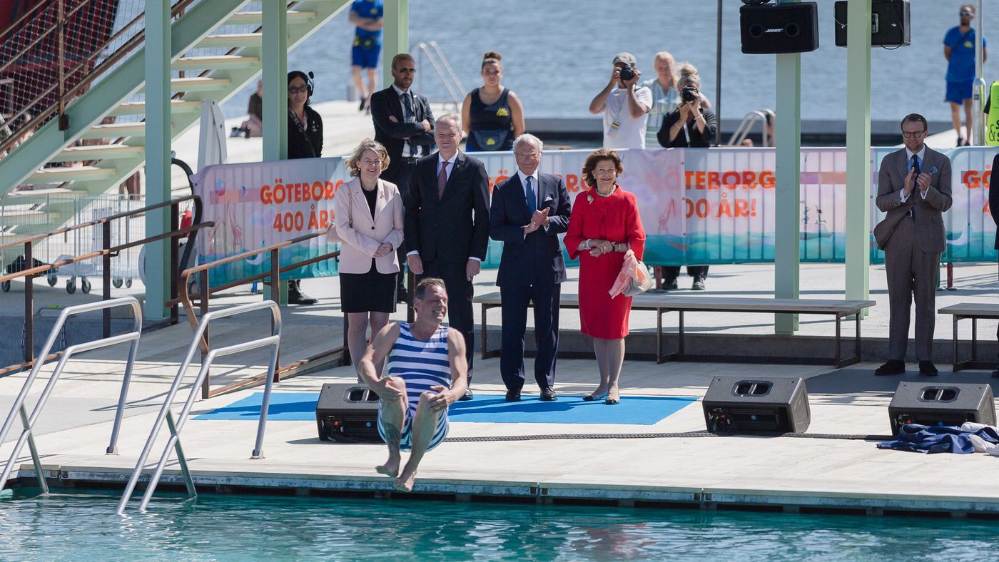 Bild av HM Kungen och drottningen vid invigningen av Jubileumsparken - en man gör bomben ner i poolen
