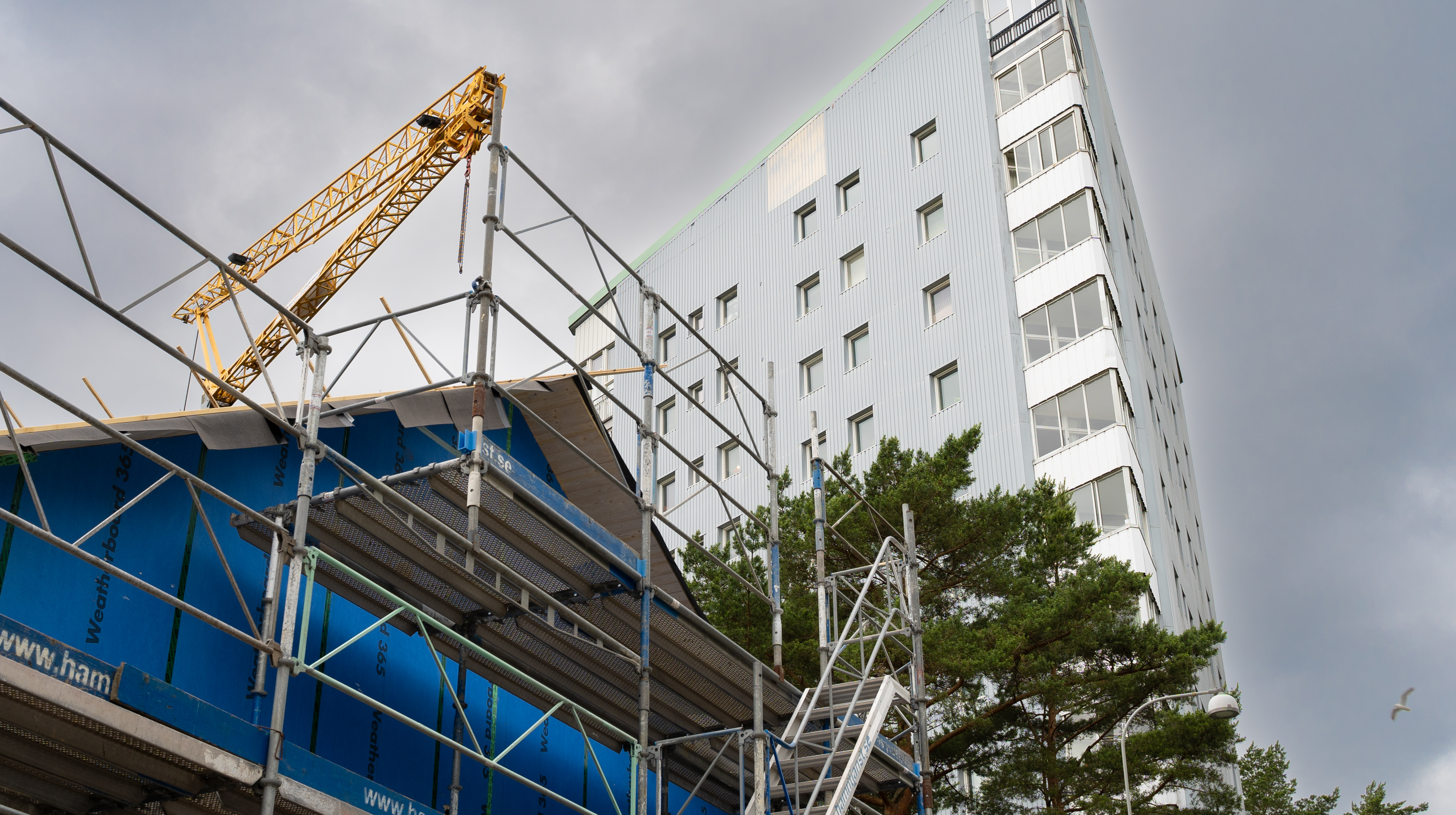 Ett pågående byggprojekt av ett BmSS-boende syns i förgrunden. I bakgrunden syns de karaktäristiska trekantshusen ipå Julianska gatan.